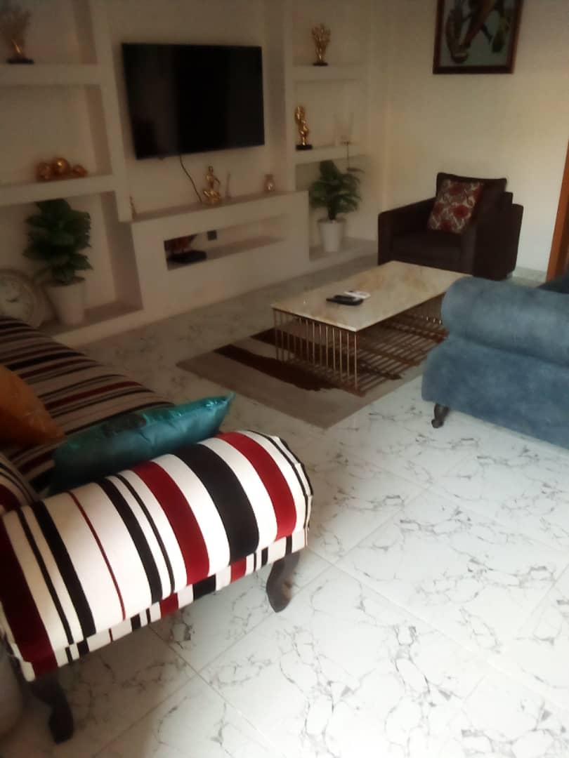 Furnished short-let living room with wall-mounted television